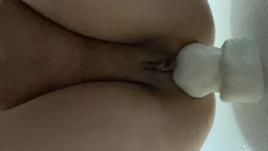 Taking huge white dildo up the butt as a wall.