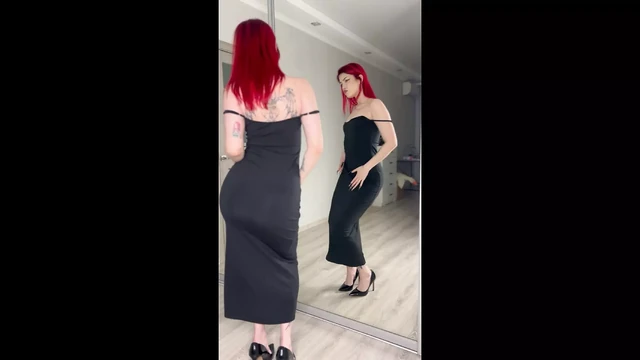 By candlelight, a red-haired, tattooed beauty enjoys herself