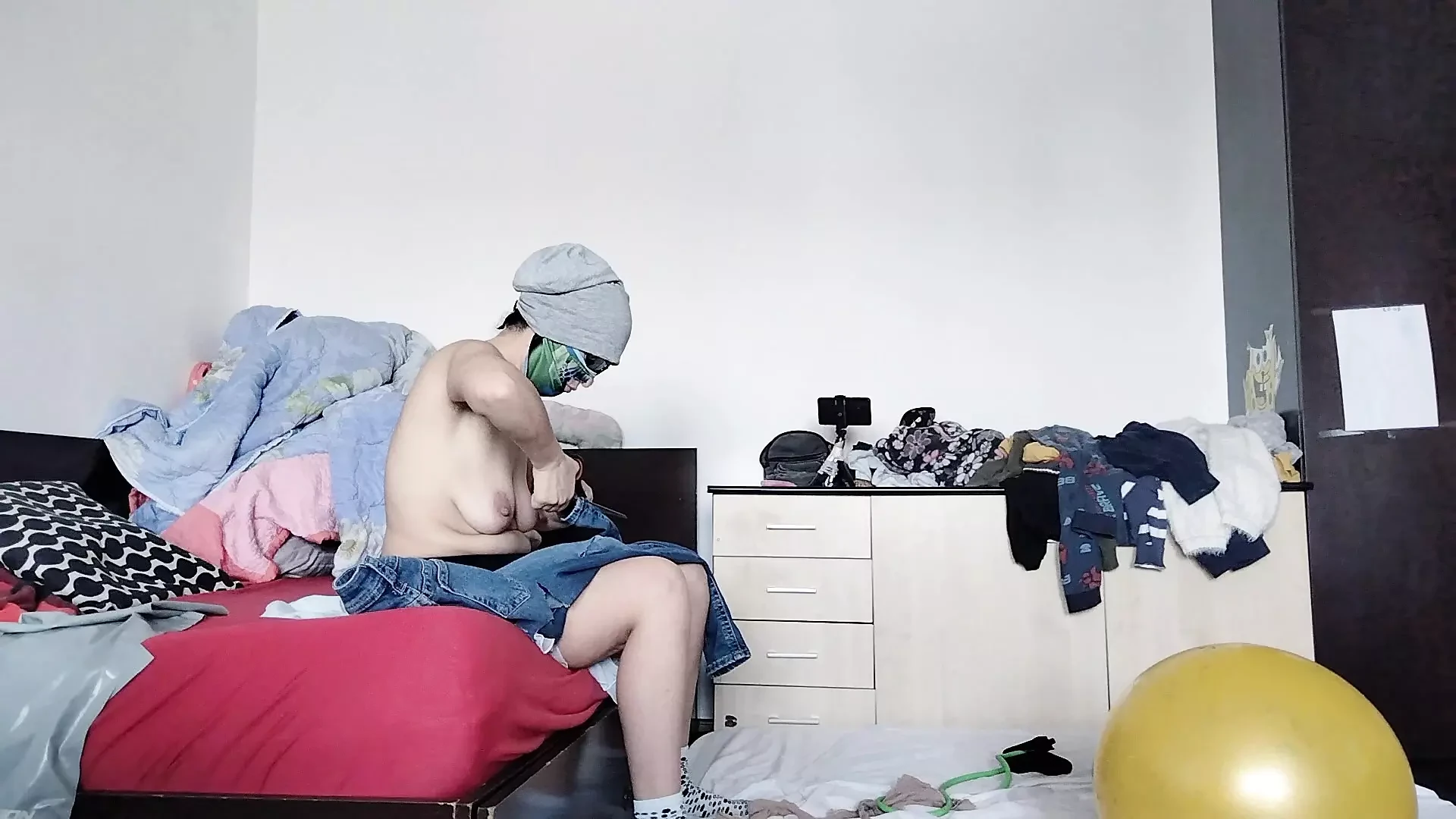 An amateur has fun trying on clothes she has cut. An amateur dances naked in the house.