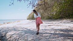 Belleza en falda meando dos veces en la playa pública, 4k