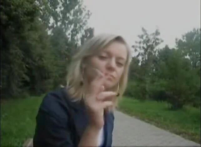Blonde beauty smoking a cigarette outdoors