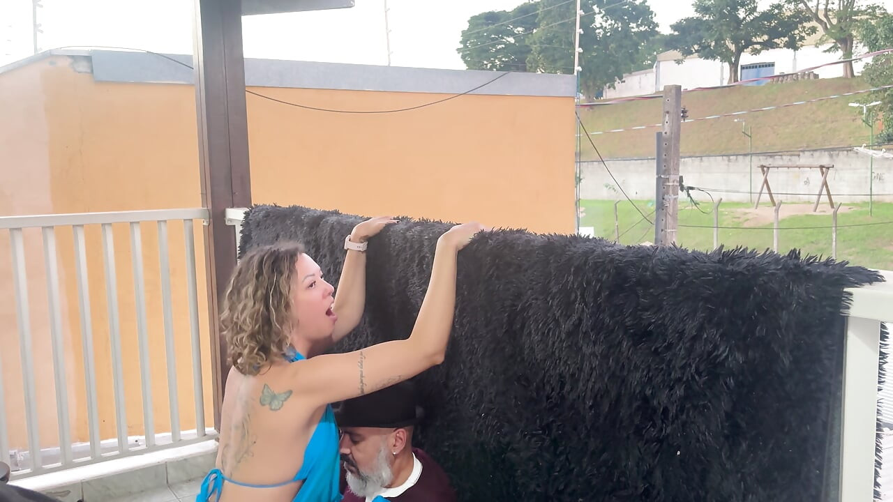 Extraños besándose en un balcón durante la fiesta.