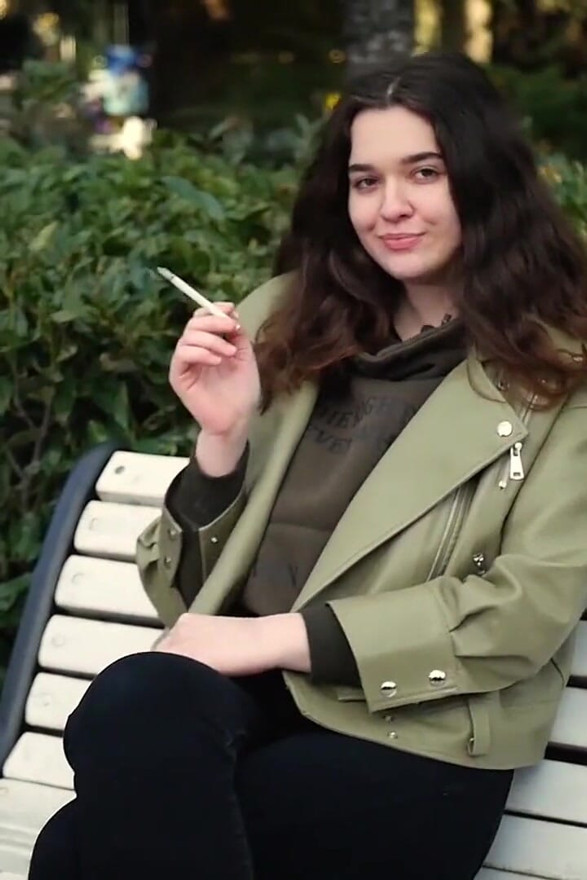 Young Brunette Is Taking an Unhurried Stroll with Allwhite 120mm Cigarette