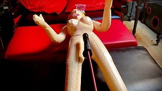 Şişme bir sarışınla sikişiyor ve güçlü bir seks makinesi onu götten sikiyor, inliyor ve seks odasının her yerinde seks kokluyor.