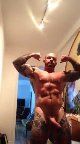 Inked muscular dilf flexes with his big cock out