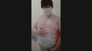 穿着可爱泳衣的微胖女男在淋浴时