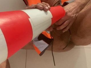 Meando en el sitio de trabajadores de la construcción con cono naranja