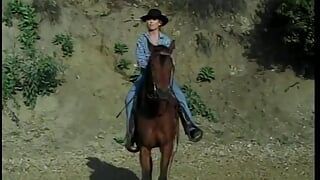 年轻美丽的金发女郎在遇到英俊的牛仔时正在骑马