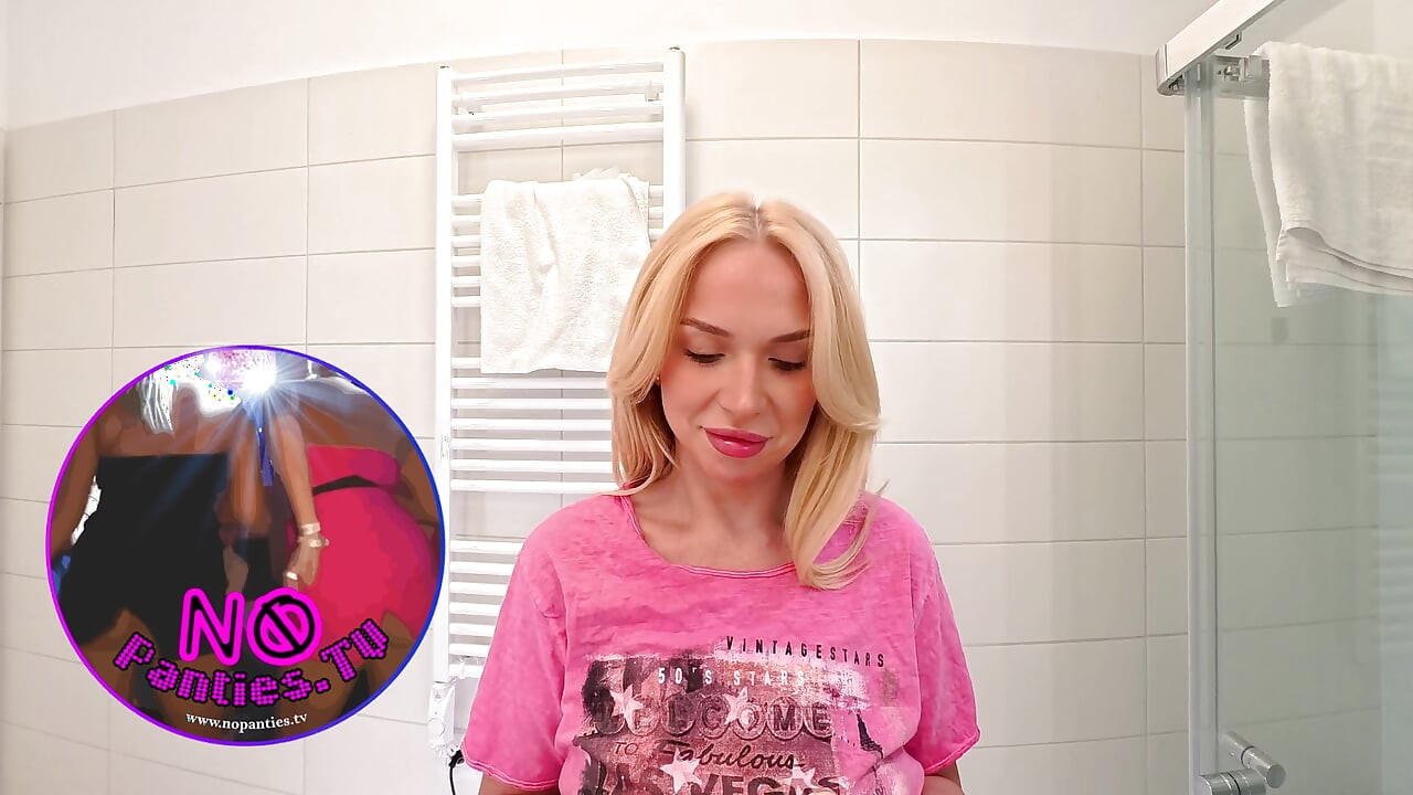 Blonda super fierbinte uimitor de frumoasă, cu țâțe mari naturale, își atinge pizda și chiloții sub fustă în baie