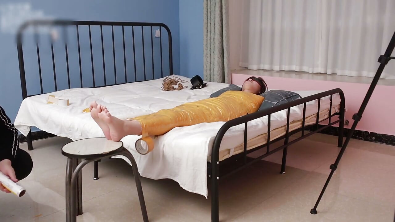 A Cute Barefoot Girlfriend Uses Tape to Bind Her Whole Body, Playing with Her Cute Bare Feet