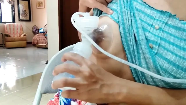 Asian with very lopsided big boobs pumps milk
