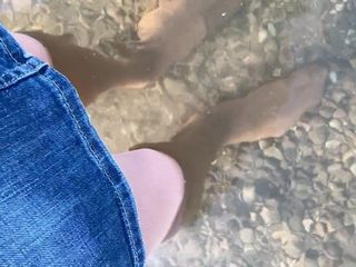 Crossdresser em meia-calça multicamadas caminhando em um lago
