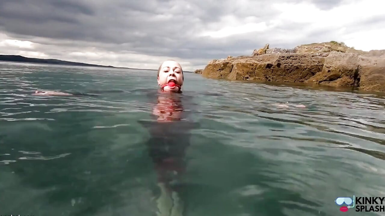 वेटसूट में बॉलगैग के साथ महासागर रस्सी बंधन