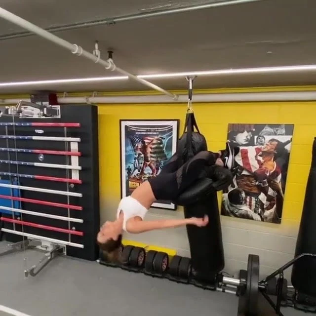 Kate Beckinsale clinging to punching bag with her legs