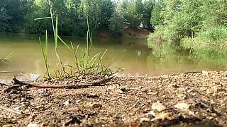 Câmera lenta pulando no lago com roupas. molhada e divertida