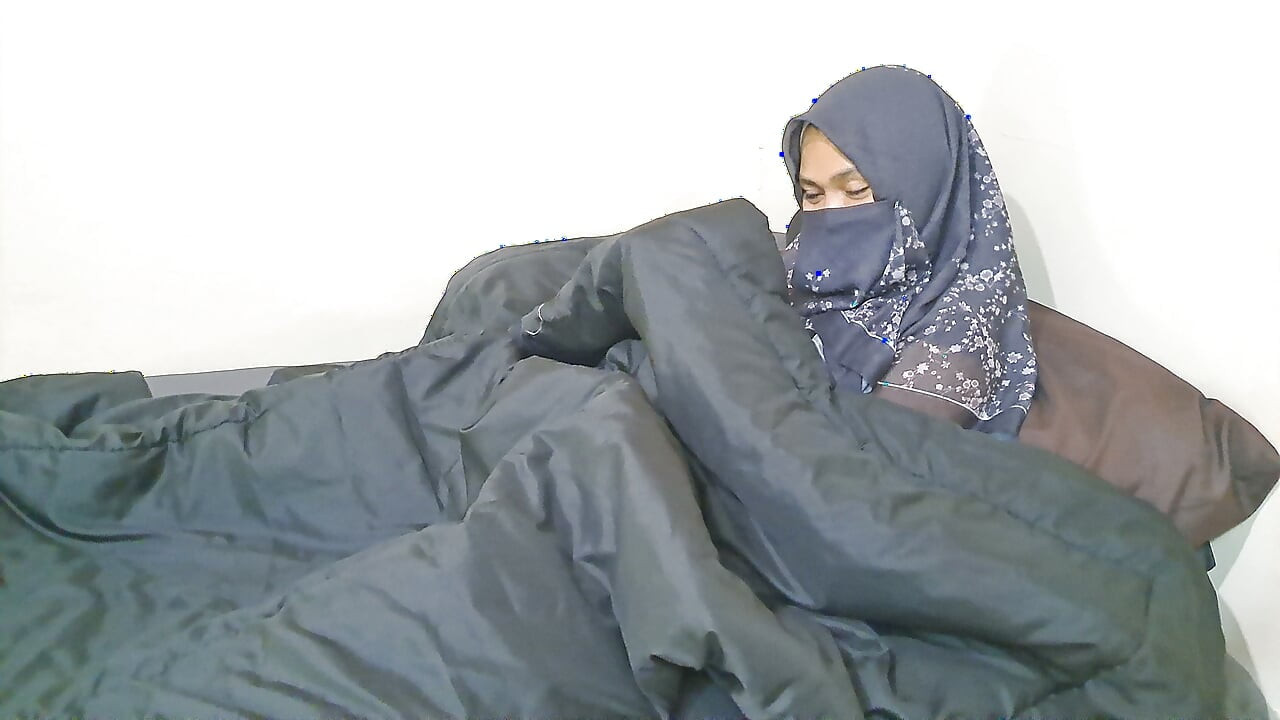 A woman in a hijab is masturbating on the sly.