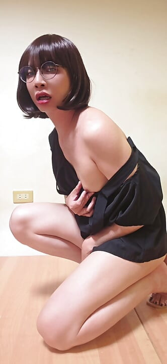 Transsexuala Ting Xuan se masturbează în timp ce poartă o rochie sexy și tocuri înalte.