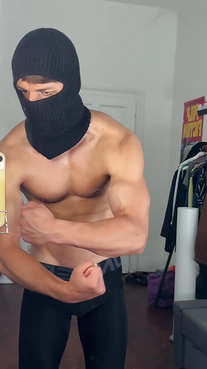 Masked hunk flexing his muscles in a tight leggings
