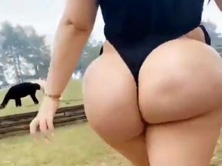 Woman with big buttocks walks in the field