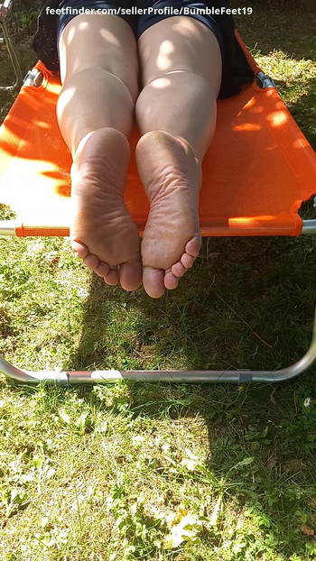 I'm laying on my belly outside in the sun. I wriggle my toes and I show my soles.