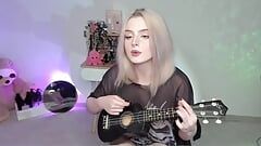 Gorąca blondynka gra na ukulele i śpiewa w niegrzecznym stroju