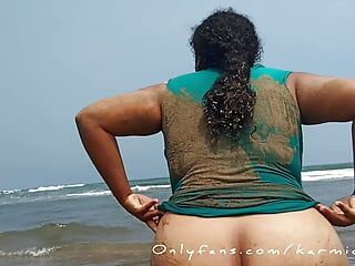 Zwangere sletvrouw toont haar poesje op een openbaar strand