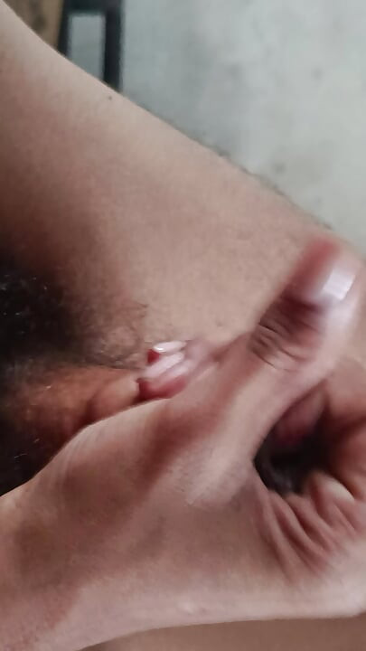 The boy is shaking his penis in his hand and ejaculating.