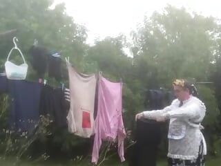 Em roupa de plantador pendurando roupa lavando roupa