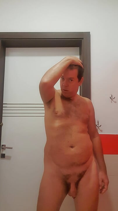 A boy completely naked in a station bathroom