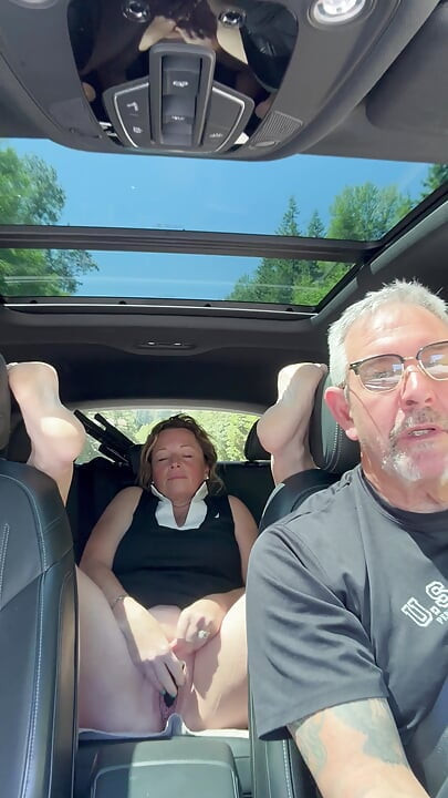 Vrouw speelt met haar poesje op de achterbank terwijl papa rijdt, roadtrip