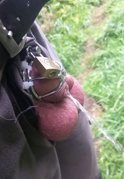 Cuckold with helpless small cock and chastity cage pisses outdoors