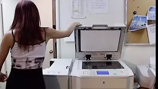 Cute peacheriono with flaming auburn hair  asked her work fellow to explain how to use the new copier