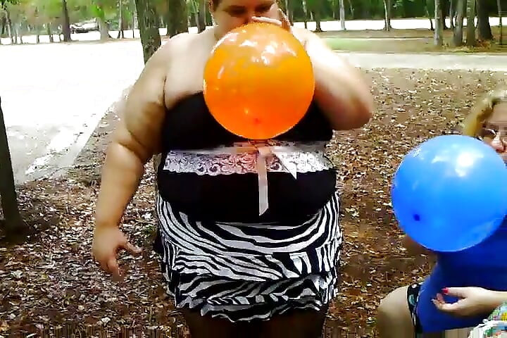 2 žene sa velikim sisama duvaju balon i lupaju