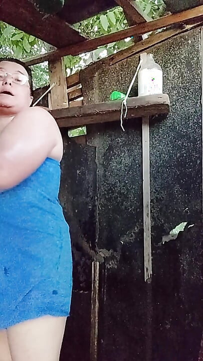 I'm watching a curvy girl wash herself in the street.