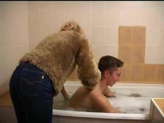 Une vieille donne un bain à un jeune homme