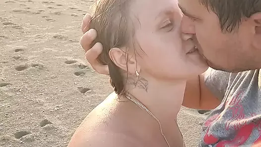 Un couple chaud sur une plage de nudistes aime se branler à l'air marin.