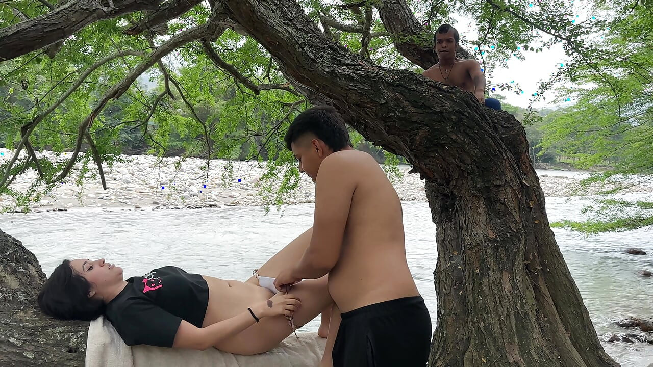 Piticul de copac se masturbează ca nebunul până când ejaculează privind cuplul sexy făcând sex pe malul râului, în aer liber.