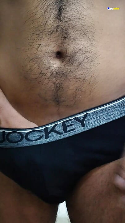 Young man wearing black underwear is dancing cock while holding his groin area.