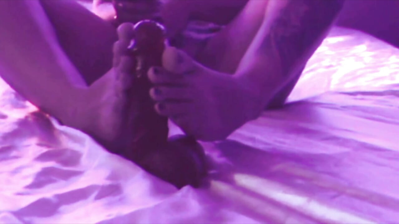 Young Girl Using Her Feet to Play with the Dildo While Masturbating