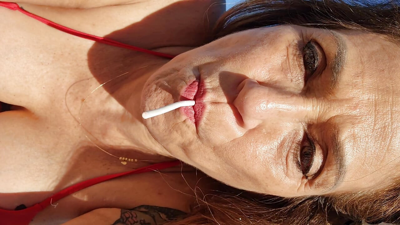Melissa Johnson sucks and licks a cherry lollipop on the .beach