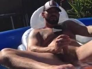 Dos gays masturbándose juntos en la piscina