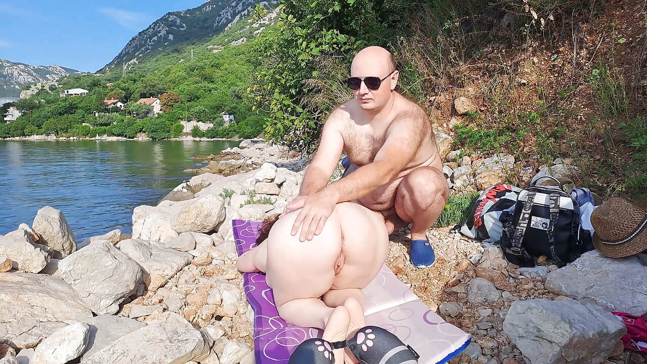 Pareja real da masaje desnudo en playa aislada
