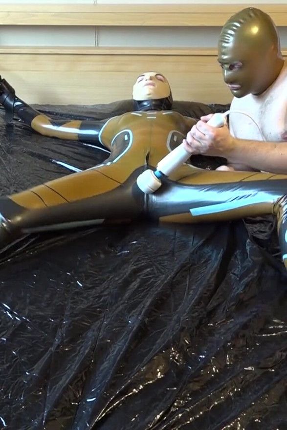 Latex Danielle is attached to the bed and masturbated with the massage vibrator