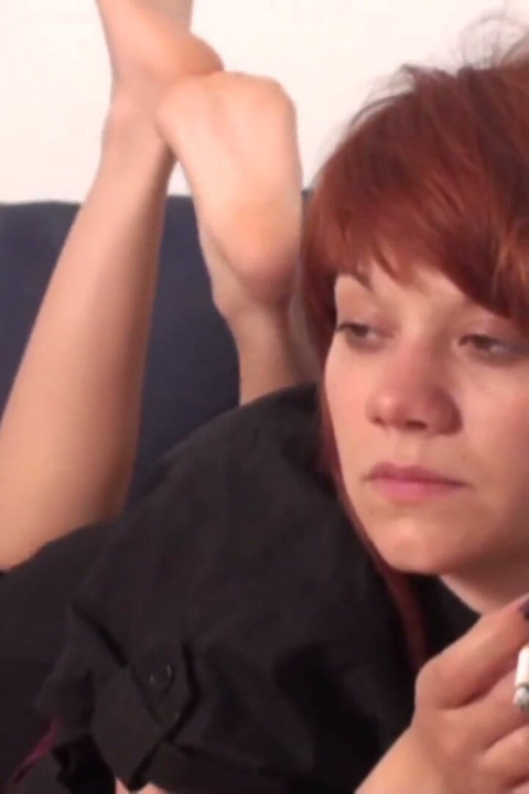 Redhead teen enjoys smoking a cigarette