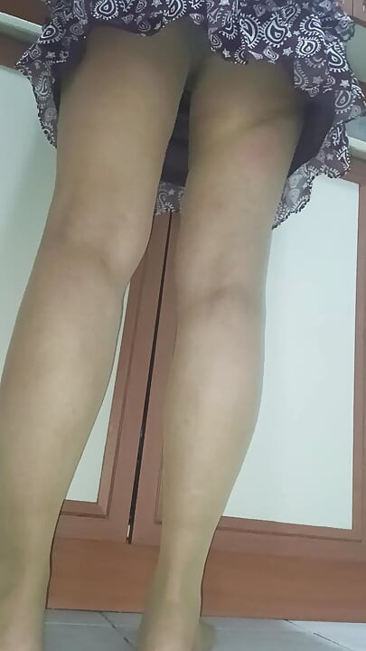 Mujer madura en medias perfectas haciendo las tareas domésticas en la cocina.