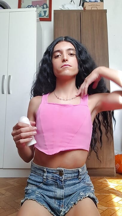 Cute shemale girl sucks the bottle of deodorant after applying lipstick