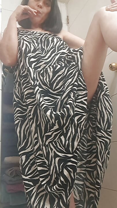 in the bathroom showing what's under her dress to her young lover on camera