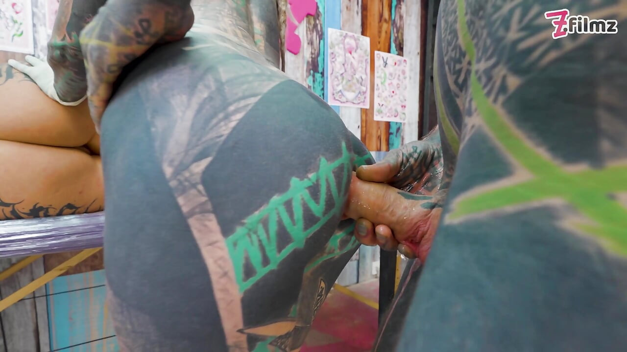 Trío anal durante sesión de tatuaje