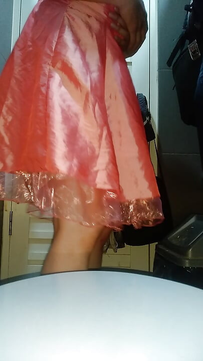 Κορίτσι με γυναικεία ρούχα και σπέρμα, φοράει χαριτωμένο ροζ σατέν μίνι φόρεμα για πάρτι