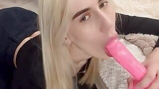 Une adolescente blonde mince taille une pipe sexy à un gode